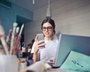 woman in white shirt using smartphone